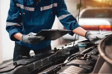 Mechanic reading a spreadsheet to perform a good quality maintenance service on a vehicle